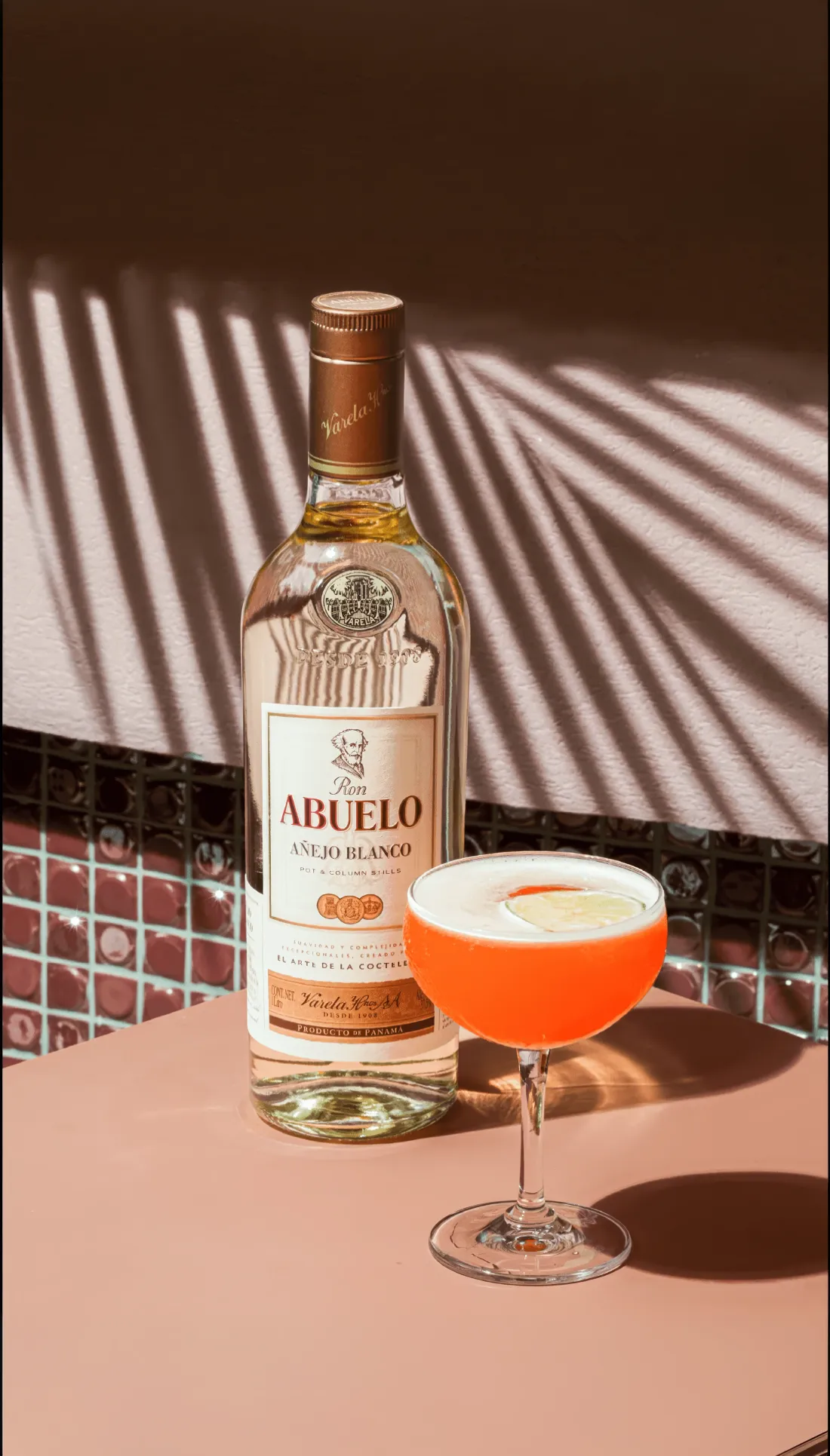 Botella de Ron Abuelo Añejo Blanco junto a un cóctel en copa coupe